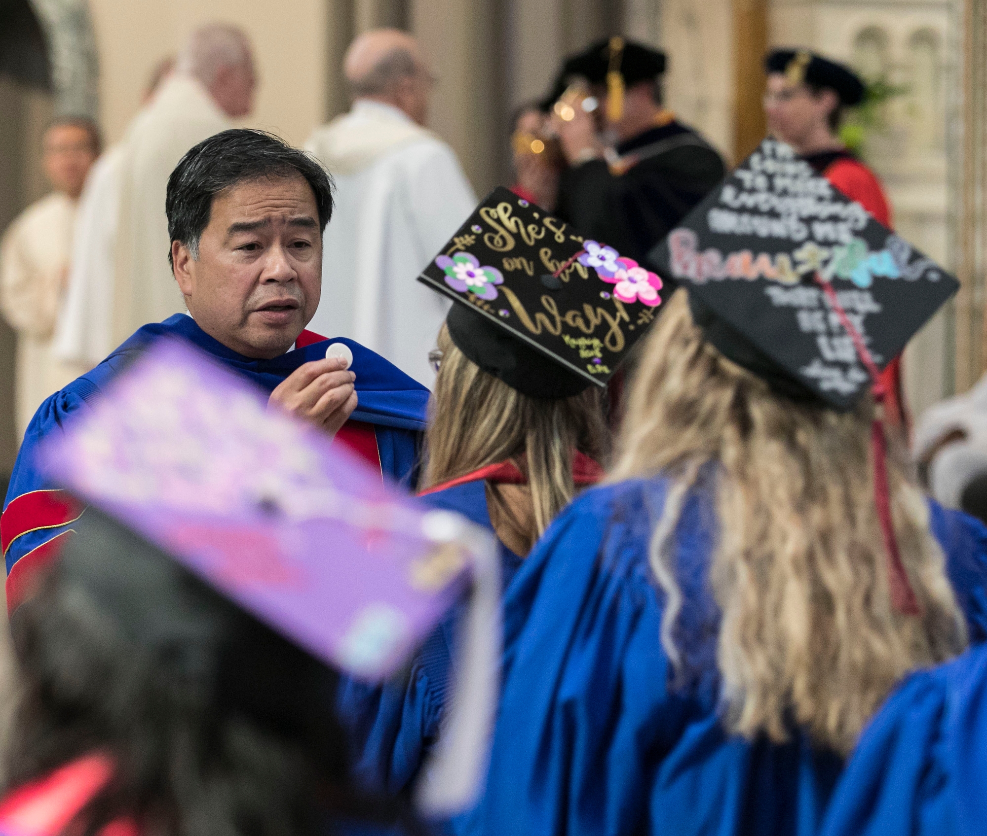 A. Gabriel Esteban, Ph.D., president of DePaul University, serves as a eucharistic minister distributing Holy Communion during the annual Baccalaureate Mass. (DePaul University/Jamie Moncrief)